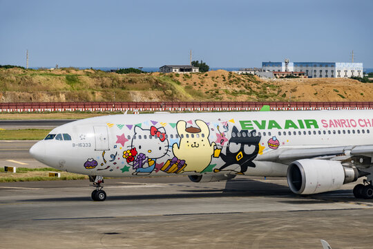 EVA Air(長榮航空) logo on an aircraft featuring Sanrio characters, including Hello Kitty, Pompompurin, and Badtz-Maru, taxiing on the runway at Taiwan Taoyuan International Airport.