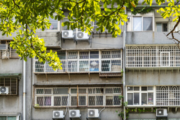 Facade of an old residential apartment building in Taipei, Taiwan, showing enclosed balconies,...