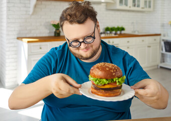 Burger on plate for plus size man to eat and enjoy. Funny hungry overweight guy with round with...