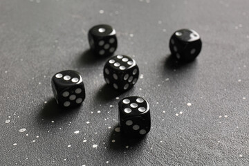 Black dices on dark background