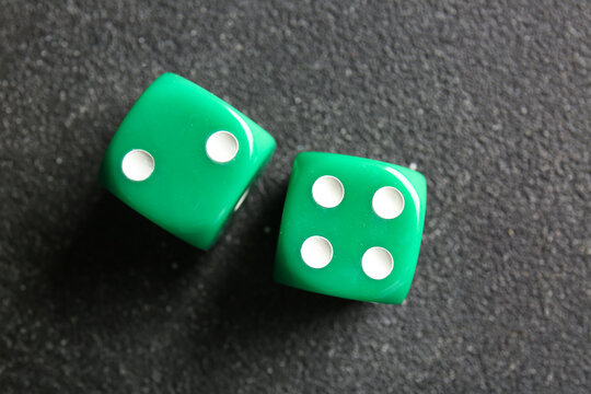 Green dices on dark background