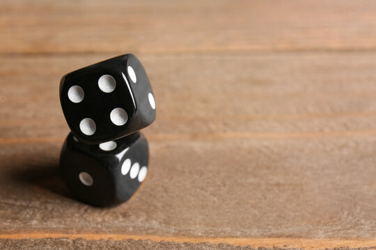 Black dices on wooden background