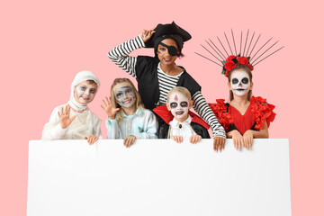 Group of children dressed for Halloween with blank poster on pink background