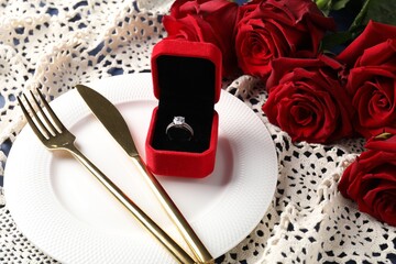 Beautiful table setting for romantic dinner, box with engagement ring and roses, closeup