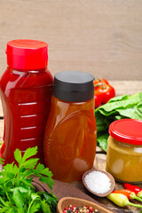 Different tasty sauces and vegetables on wooden table