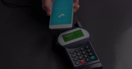 Hand holding smartphone hovering above contactless POS terminal at checkout, glossy dark countertop © vectorfusionart
