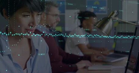 Working Asian woman typing on laptop at office desk with metallic lamp, data graphs, copy space