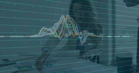 Reviewing two businesswomen analyzing printed charts at office table, with data graph overlay