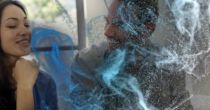 Discussing two colleagues examining digital model in modern office, with blue particle field