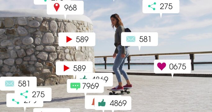 Skateboarding woman riding longboard along seafront past pillar, with backpack, social media icons - Powered by Adobe