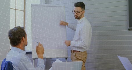 Pointing at flip chart, business professional explaining data in conference room with marker