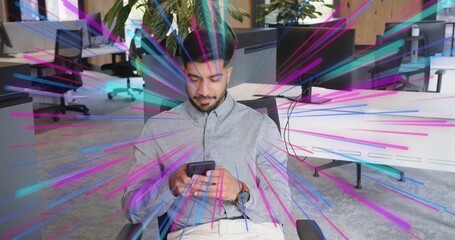 Holding smartphone, office worker sitting in mesh chair in modern office with desks monitors plants