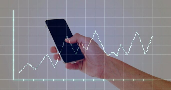 Holding smartphone in right hand against plain wall, showing digital grid and jagged line graph