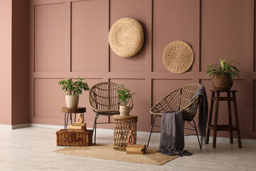 Interior of room with wicker armchairs, table and plants