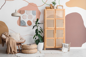 Interior of room with armchair, wicker closet and plants