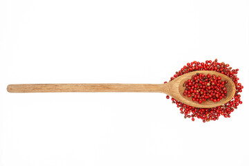 Wooden kitchen spoon filled with pink pepper isolated on white