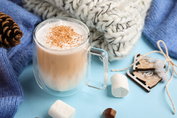 Cup of cocoa with marshmallows on blue background, closeup. Hello winter