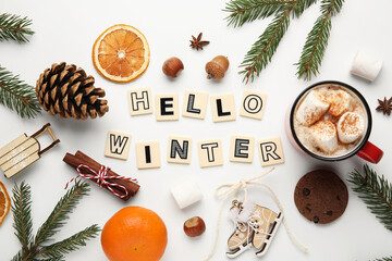 Text HELLO WINTER with nuts, citruses and cocoa on white background