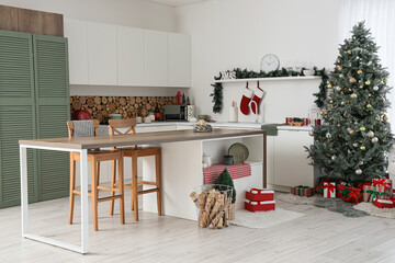 Interior of light kitchen with counters, Christmas tree and presents