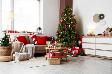 Interior of living room with Christmas tree, sofa and books on table