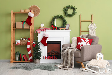 Interior of living room with Christmas wreaths, fireplace and armchair