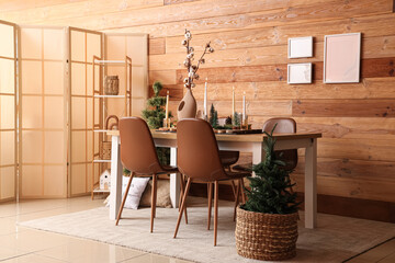 Interior of room with dining table, Christmas trees and burning candles