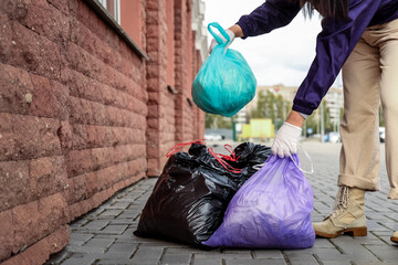 Woman leaving garbage bags on road for collection in city © Pixel-Shot