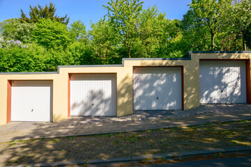Residential Garage Doors in a Row Surrounded by Trees on Sunny Day
