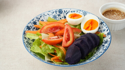 Healthy Salad Bowl, mix vegetables carrots, lettuce, tomatoes, sweet potatoes, and egg with sesame sauce.