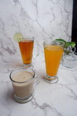 lime tea, orange juice and coffe milk on the table