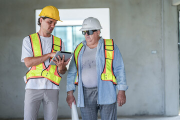 A site engineer and a foreman conduct a quality control check. The foreman uses a spirit level to verify alignment while the engineer reviews digital CAD plans on a laptop computer.