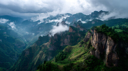 Majestic cliffs rise above green valleys in Enshi City, Hubei Province, with clouds swirling around rugged mountain peaks under a vast sky, showcasing natural beauty and dramatic landscapes.