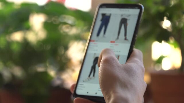 Online shopping. Buying trousers on the marketplace online, fast fashion
