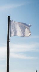 White Flag Waving in the Wind Against a Blue Sky.