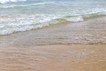 Waves turquoise blue water and sand at tropical beach Thailand.