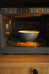 a bowl of food spilled in a microwave oven at home kitchen