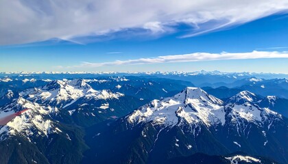 Aerial view of snowy mountain peaks under a vibrant blue sky