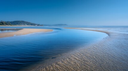 Narrow sand spit extending into a calm bay during low tide