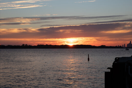 Beautiful sunset over calm water with warm orange sky and reflections