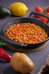 Chickpeas simmering with fresh vegetables in a skillet