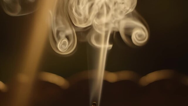 Smoke Rising From Incense Stick Against Dark Background