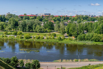 Fototapeta premium Neman River flowing through green hills in Hrodna, Belarus above the lush riverside landscape. 