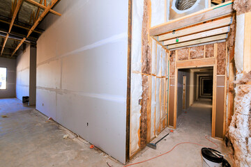 Drywall installation is ongoing, an empty commercial space hallways under construction