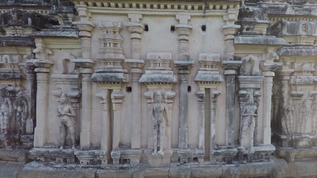 Drone camera rises vertically to reveal ornate Virupaksha Temple gopura details in summer day.