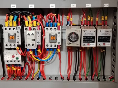 Intricate wiring of an industrial electrical control panel.