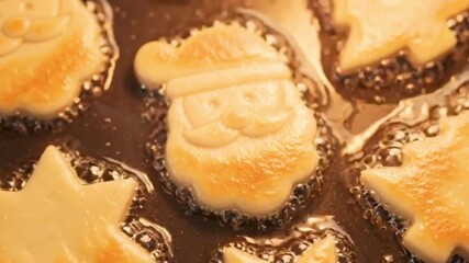Golden Santa cookies sizzling in a cozy Christmas kitchen, spreading festive warmth, sweet aroma, and joyful holiday baking vibes – generative AI.
