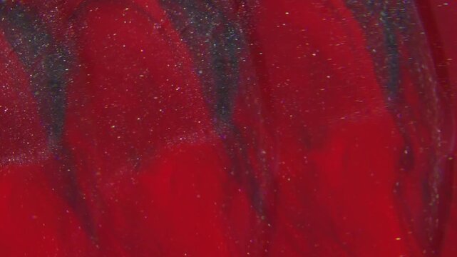Vivid paint stream. Blur sparkling blend. Color glitter spilling defocused lens. Red dye dissolving in black liquid blur abstract background.