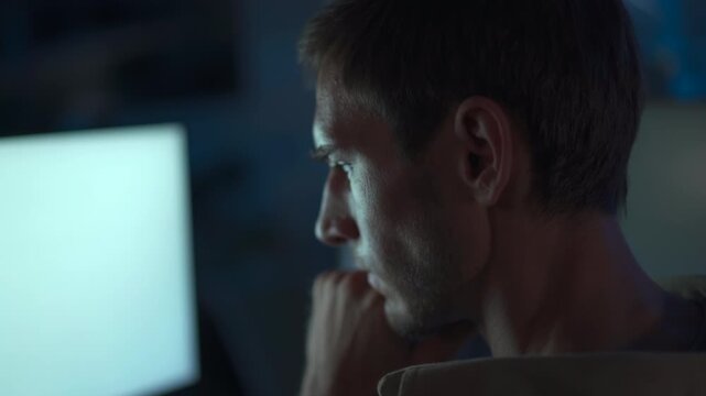 Cybersecurity engineer working late at computer in dark office