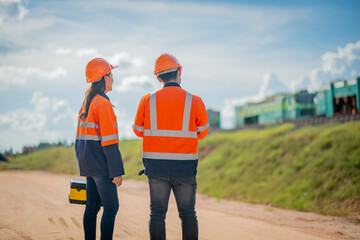 Construction engineer inspecting railway track industrial documents in hand while examining rail...