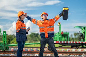Construction engineer inspecting railway track industrial documents in hand while examining rail structure closely construction, safety and professional project management transportation development.